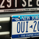 A New York license plate underneath an original French plate on a Citroën 2CV.